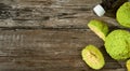 Fruit of the Maclura pomifera tree or horse apple on a wooden table. Sliced Ã¢â¬â¹Ã¢â¬â¹Adam`s apple for medical use, bottle of Maclura